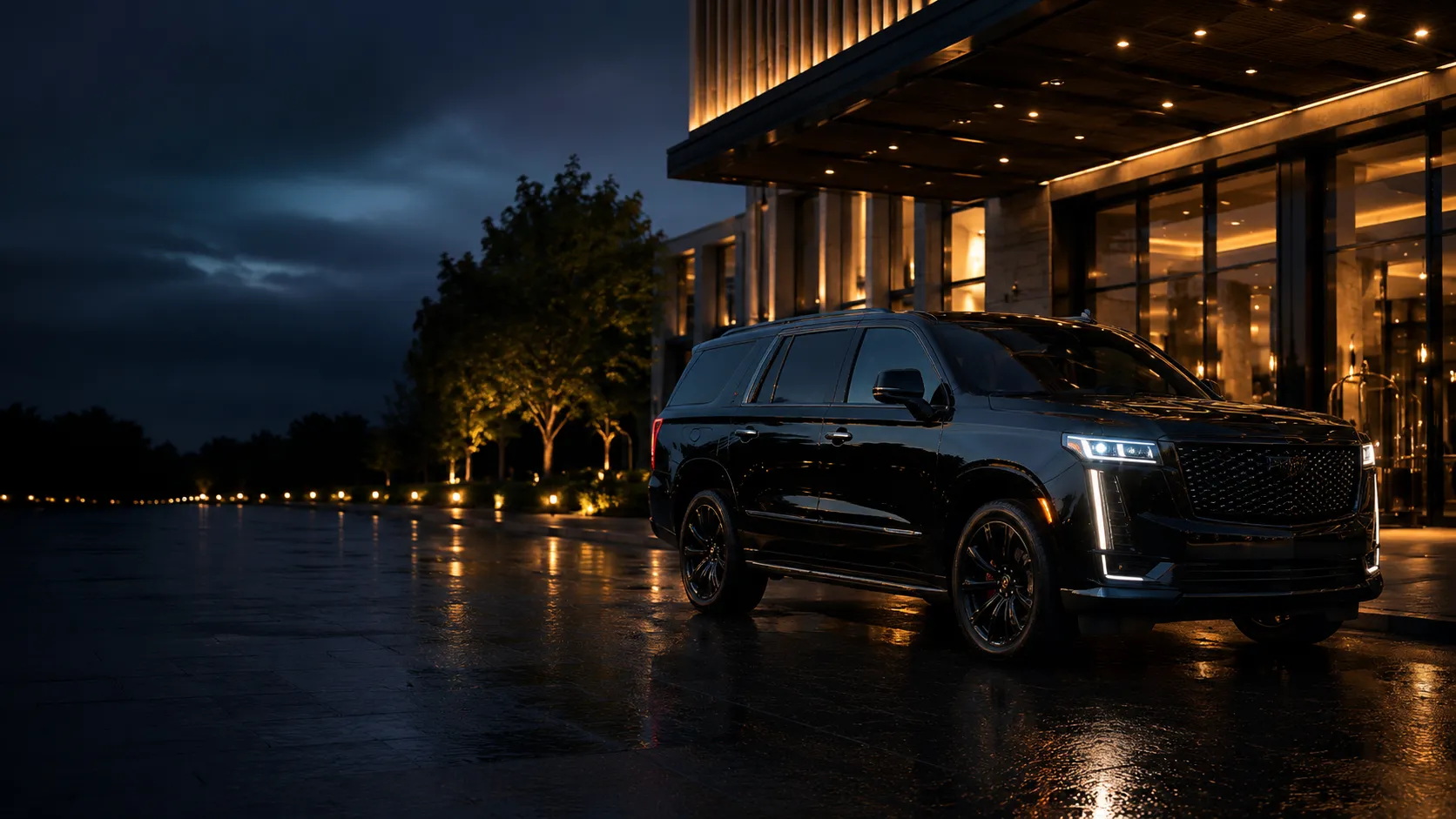 A black executive SUV waiting under a hotel's illuminated porte-cochère at night, rain-slicked pavement reflecting the warm entrance lighting