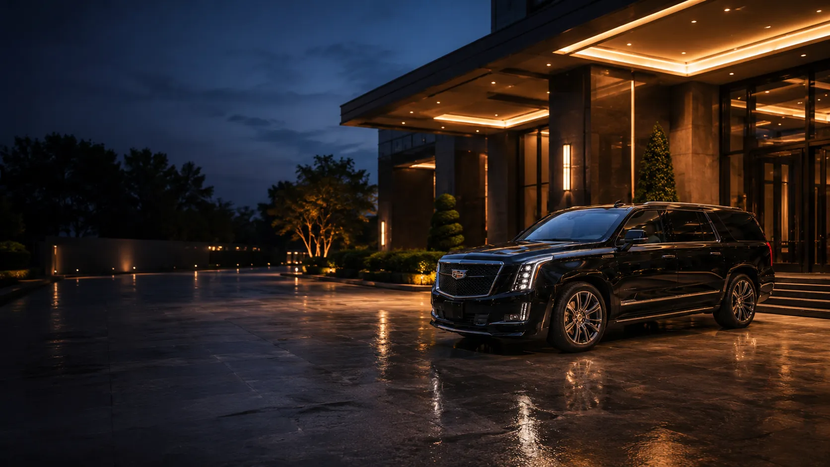 A black luxury SUV waiting under an upscale hotel's illuminated entrance at blue hour, with the porte-cochère lighting and building glowing warmly behind it